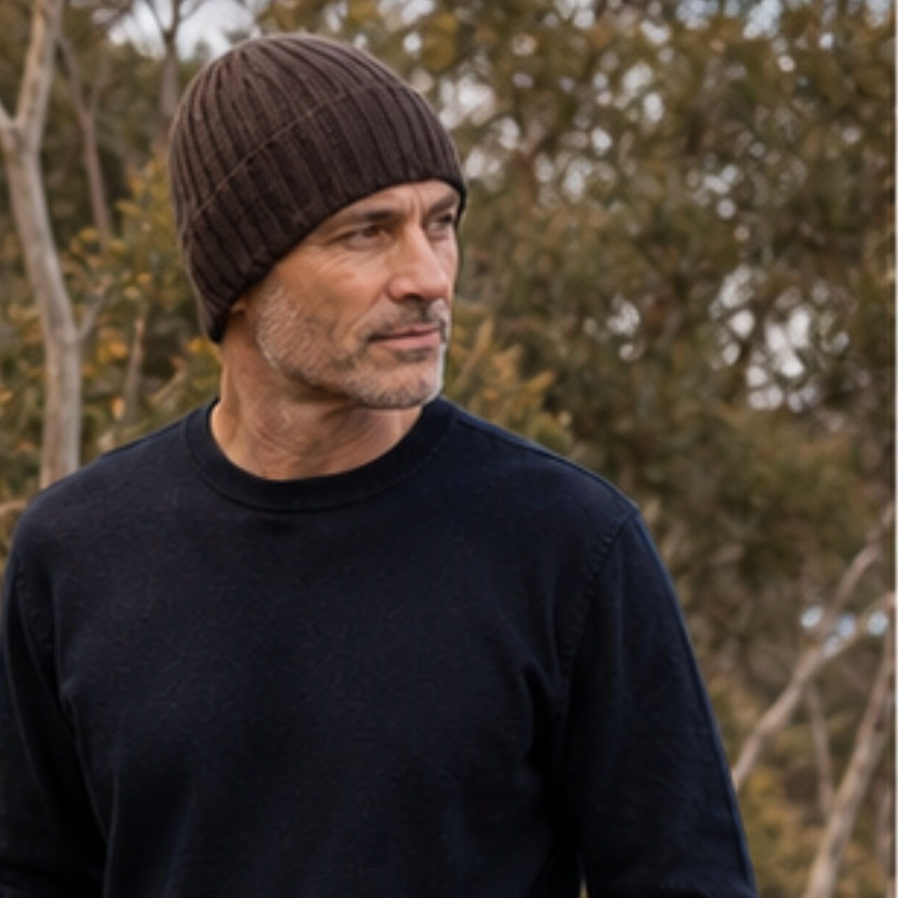 Man wearing a black sweater and brown beanie outdoors with app interface elements.